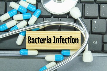 pills, laptop keyboards and wooden boards with the word bacteria infecti. bacteria infection concept