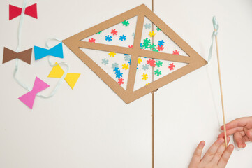 The child is creating a kite. The detail of the puzzle is a symbol of autism. Easy 5 minute crafts. Early preschool education for young children. Zero waste. DIY games at home.