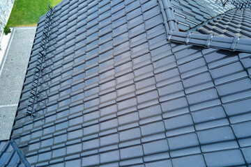 Closeup of house roof top covered with shiny ceramic shingles