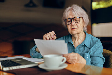 elderly woman working in front of laptop monitor sitting Retired woman chatting unaltered