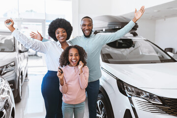 Excited Afro family showing key, shouting WOW, feeling happy over buying new auto, raising hands up...