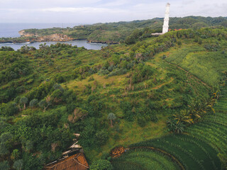 Aerial view of Baron beach in Yogyakarta, Indonesia with lighthouse and traditional boats