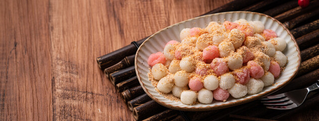 Deep-fried red and white tangyuan with peanut powder.