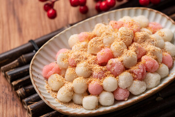 Deep-fried red and white tangyuan with peanut powder.