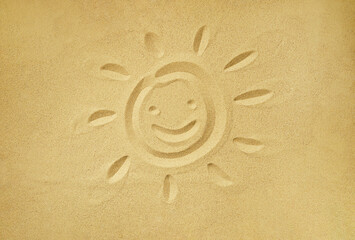 Fototapeta na wymiar smiling sun face drawn in sand, summer beach holiday