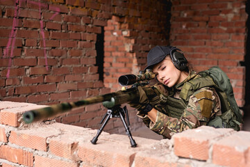 attractive caucasian woman soldier with sniper rifle with telescopic sight, keep defense in battle...