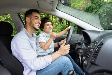 Young Arab Father Giving Driving Lessons To His Little Son