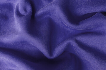 Fabric with waves colored in violet color of the year 2022. Trendy color very peri. Fabric backdrop, cloth texture, view from above.