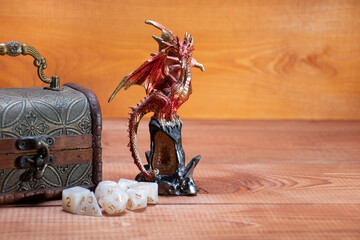Ivanovo, Russia - 02.11.2021: D20 and set of role playing white dices, toy miniature of dragon and storage box for playing Dungeons and Dragons role-playing game on wooden background