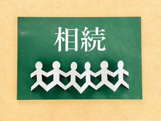 黒板に相続の文字とつながった紙人形