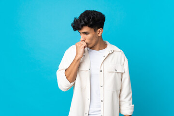 Young Argentinian man isolated on background having doubts