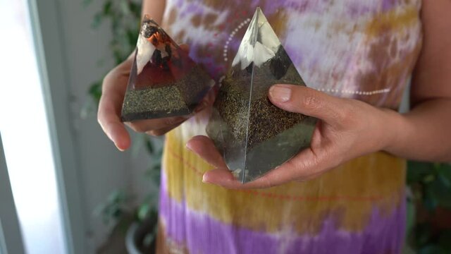 Woman holding two orgone stone pyramids to purify energies