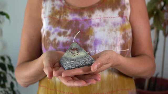 Woman feeling the energies of an orgonite pyramid