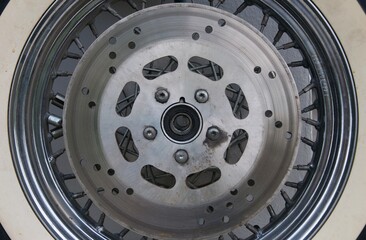 motorcycle front wheel with tyre and disk brakes , background of vintage wheel motorcycle disc brakes in local garage