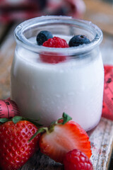 yogurt with wild berries and measuring tape. diet and eating concept