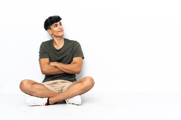 Young Argentinian man sitting on the floor in lateral position