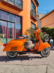 Fototapeta na wymiar old retro orange moped at city street