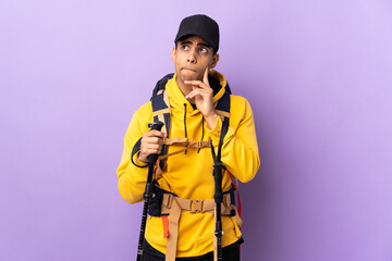 African American man with backpack and trekking poles over isolated background having doubts and thinking