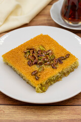 Pistachio kadayif dessert on wooden background. Traditional Turkish cuisine flavor. close up