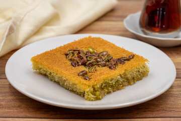 Pistachio kadayif dessert on wooden background. Traditional Turkish cuisine flavor. close up