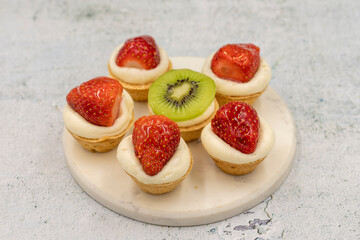 Delicious tiny tartlets (tarts, open pastry pies) on a stone background. close up