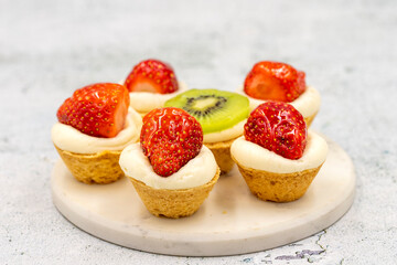 Delicious tiny tartlets (tarts, open pastry pies) on a stone background. close up