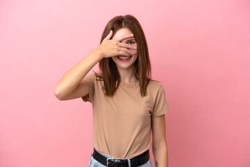 Young English woman isolated on pink background covering eyes by hands and smiling