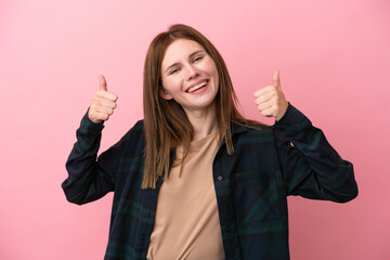 Young English woman isolated on pink background giving a thumbs up gesture