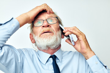 old man with phone shocked in studio on white background