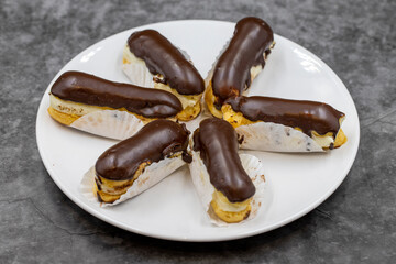 Chocolate eclair cake on dark background. Traditional french dessert. Pastry products. close up