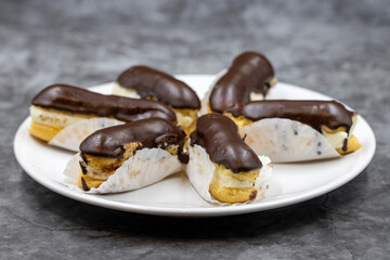 Chocolate eclair cake on dark background. Traditional french dessert. Pastry products. close up