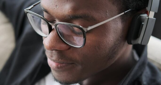 Close up face of African American man listening music on headphones at home