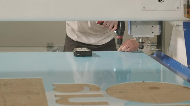 Production of advertising signs in the factory. Screwdriver tightens the screw