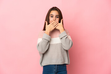 Little girl isolated on pink background covering mouth with hands