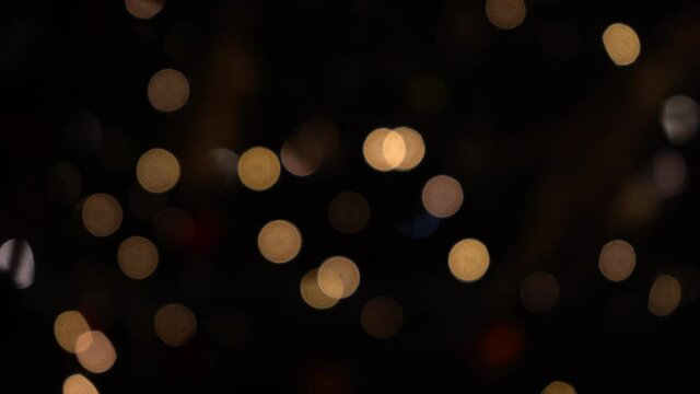 Bokeh of lights of garlands. Blurred soft focus. The garland is flashing. City lights at night. Christmas mood. Abstract blurred Christmas tree flicker. Winter vacation concept.