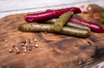 A close -up of roasted vegan sausages on a vintage wooden cutting board, selective focus. Meat free...