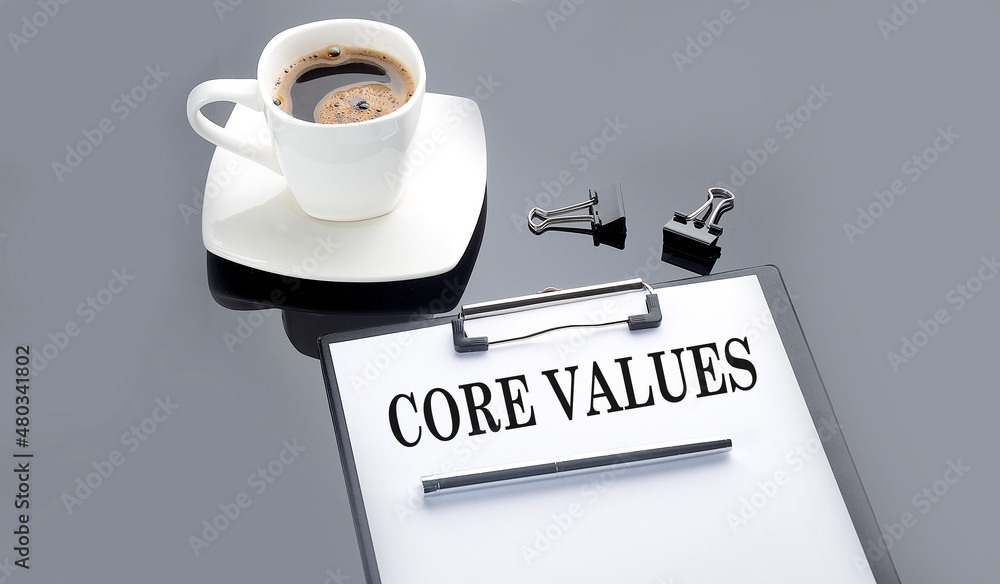 Aufkleber core values text on paper sheet with coffee on the black background