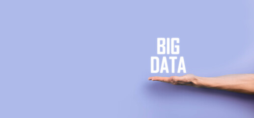 Businessman in a suit on a dark background holds the inscription BIG DATA. Storage Network Online Server Concept.Social network or business analytics representation