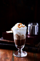 Coffee with whipped cream on dark background. Soft focus. Close up.	