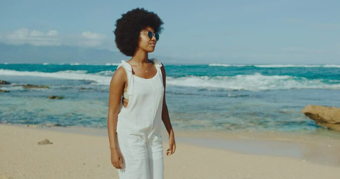 Happy young stylish black woman relaxing at the beach, morning afro beach vibes, happy fashion lifestyle