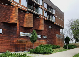 A beautiful wooden apartment building with a well-groomed territory near in summer time against a sky.The concept of rent and buying real estate