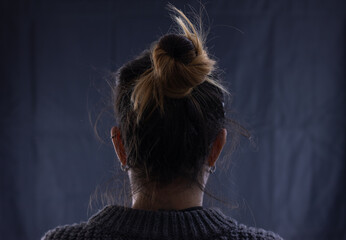 Girl from behind with collected hair on black background