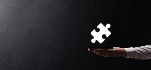Businessman hands connecting puzzle pieces representing the merging of two companies or joint...