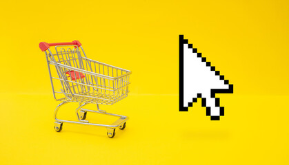 Empty trolley cart and mouse cursor on yellow surface. Online shopping concept