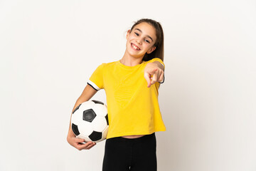 Little football player girl isolated on white background pointing front with happy expression