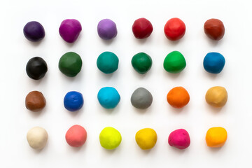 Pieces or balls of Colorful plasticine modelling clay isolated on white background. Top view with...