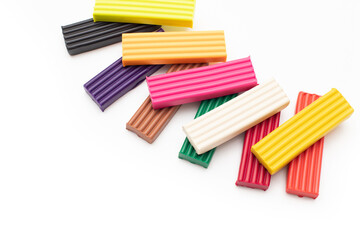 Obraz premium colored plasticine modelling clay pieces or sticks on isolated white background with clipping path. Top view, closeup, frame border with copy space.