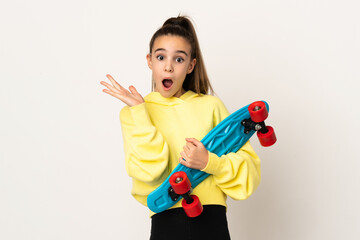 Little girl isolated on white background with a skate and doing surprise gesture