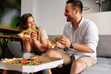 Couple eating pizza at home