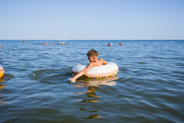 a young boy in a swimming circle in the summer at the sea